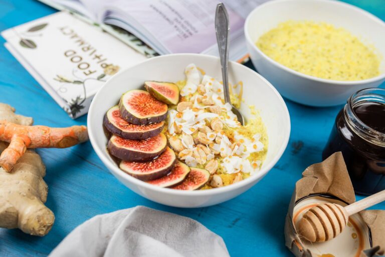 Bol de petit déjeuner aux figues, noix et yaourt posé sur une table bleue